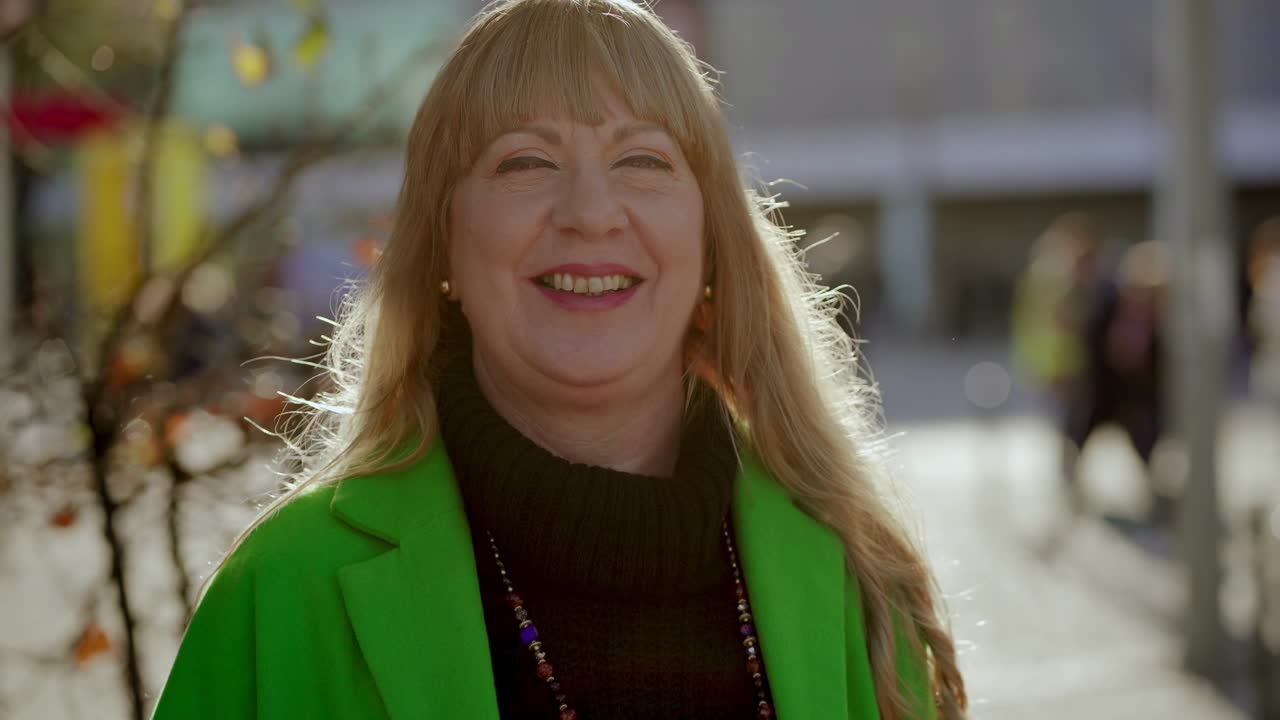 행복 한 성숙 한 여자 는 카메라 를 쳐다보고 엄지 손가락 을 올리고 있다