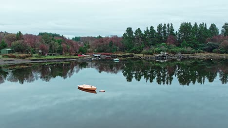 sneem anillo de kerry irlanda salvaje atlántico camino temprano mañana de otoño aguas tranquilas en un puerto con un barco y sombras de árboles en el agua