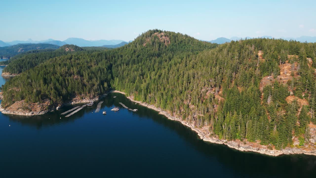 aerial shot of Read Island revealing oyster farm and mountains in the background, Discovery Islands, strait of Georgia, British Columbia, Canada