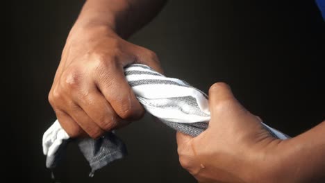 person wringing out a wet towel