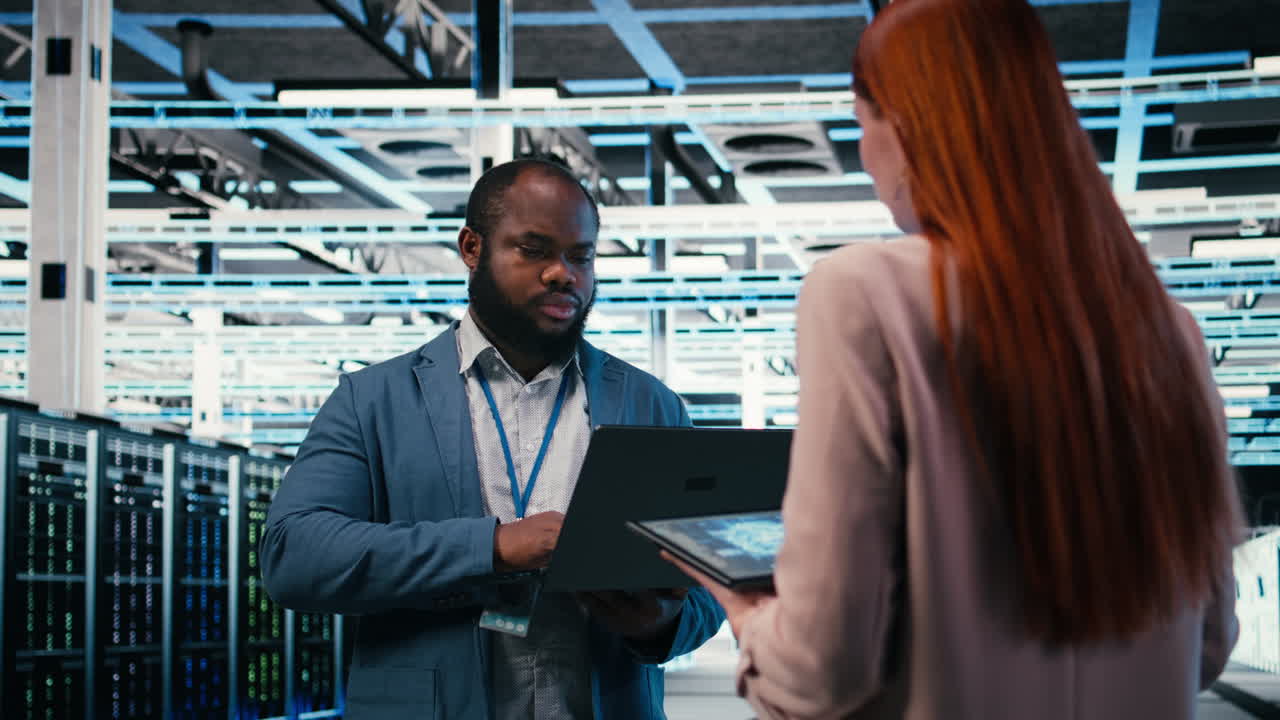 IT Engineers Discussing Data Center Operations with Laptop and Tablet