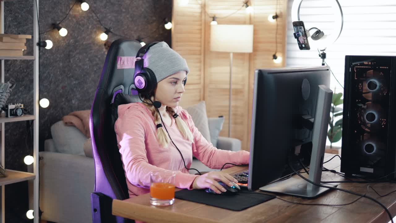 joven streamera juega videojuegos en casa en la computadora y se comunica con la audiencia mientras transmite
