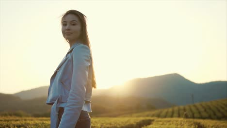 woman in a blue jacket at sunset tea plantation