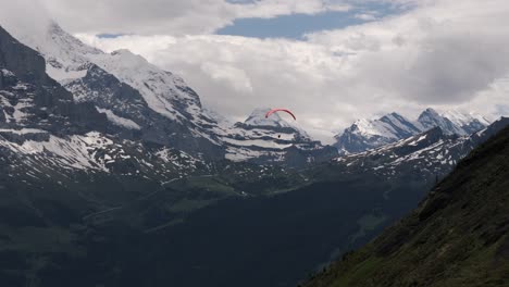 following paraglider with broad alpine view in grindelwald valley