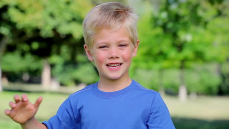 boy smiling and waving before giving the thumbs up