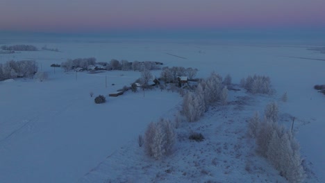 Toma-Aérea-De-Establecimiento-De-Un-Paisaje-Rural,-Casa-De-Campo,-Campos-Agrícolas-Y-árboles-Cubiertos-De-Nieve,-Clima-Helado,-Luz-De-La-Hora-Dorada-De-La-Puesta-Del-Sol,-Toma-Amplia-De-Drones-Que-Avanza-Lentamente