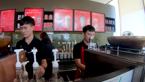 unidentified starbucks employee prepares drink at don mueang international airport outlet of starbucks in bangkok, thailand.