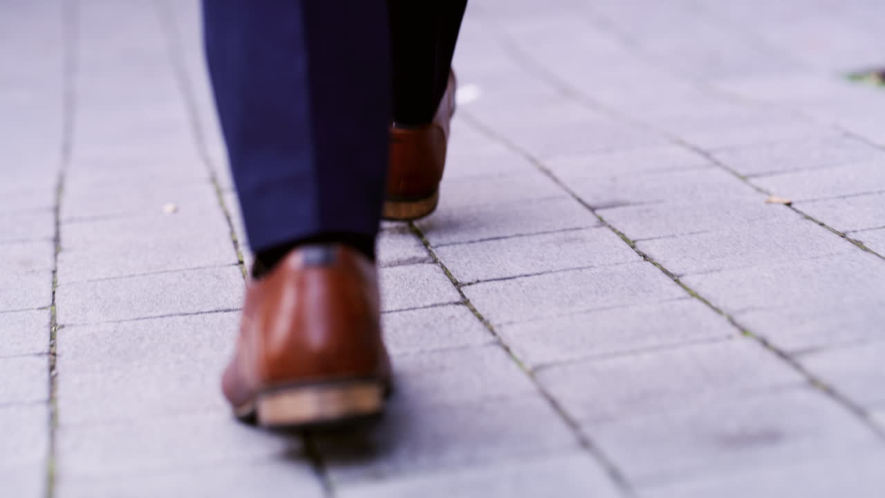 hombre caminando por la calle de adoquines en traje de negocios