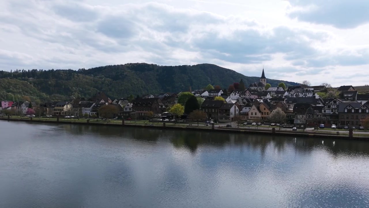 Vista aerea con drone che vola basso sulle acque calme del fiume Mosella e sulla città di Cochem in Germania. Spazio per il testo.