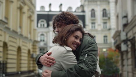 una pareja feliz abrazada en el centro de la ciudad, una mujer y un hombre disfrutando del tiempo juntos.