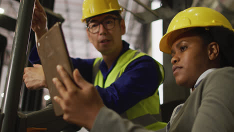 Diversos-Trabajadores,-Hombres-Y-Mujeres,-Que-Usan-Trajes-De-Seguridad-Y-Usan-Tabletas-En-El-Almacén