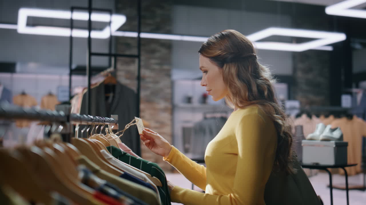 Lady buyer looking prices choosing clothes at boutique closeup. Woman customer