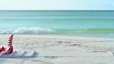 Christmas-Gnome-on-the-beach-in-a-white-sled-on-a-sunny-winter-day