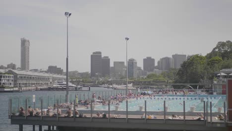 Plano-General-De-Una-Piscina-Pública-Con-Mucha-Gente-Nadando-Durante-Un-Día-Soleado-De-Verano