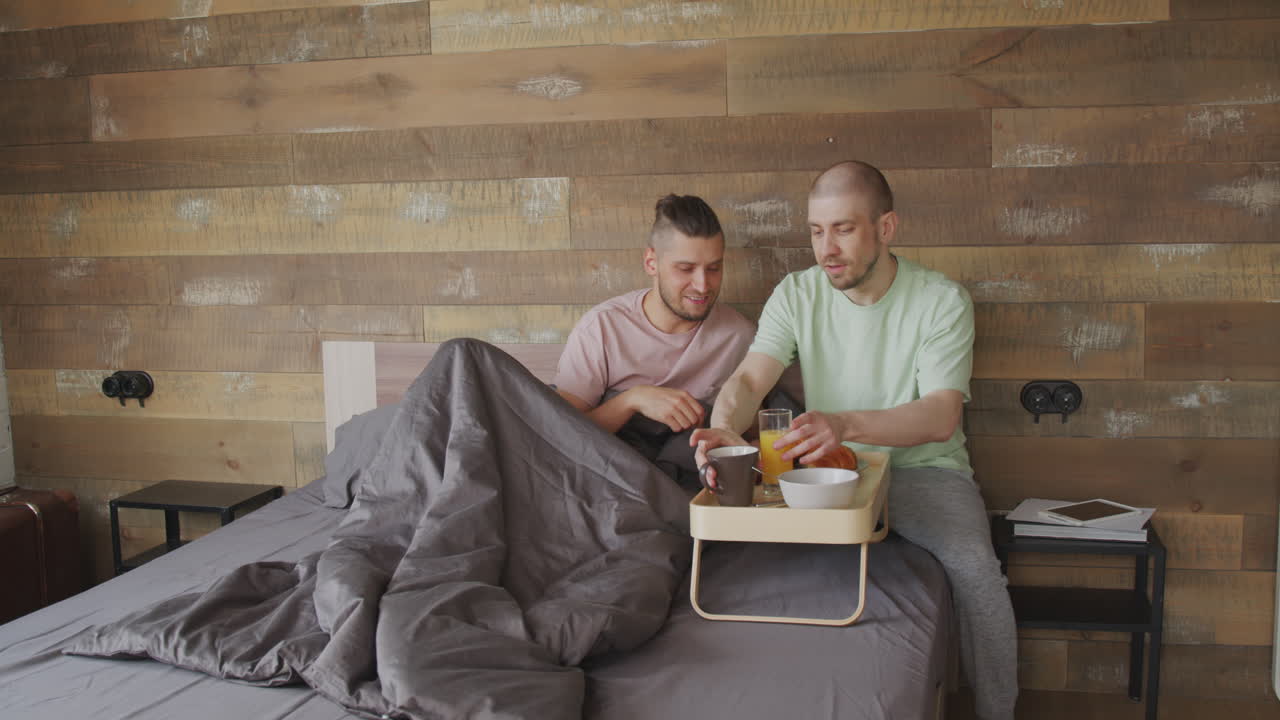 Man Surprising Boyfriend with Breakfast in Bed