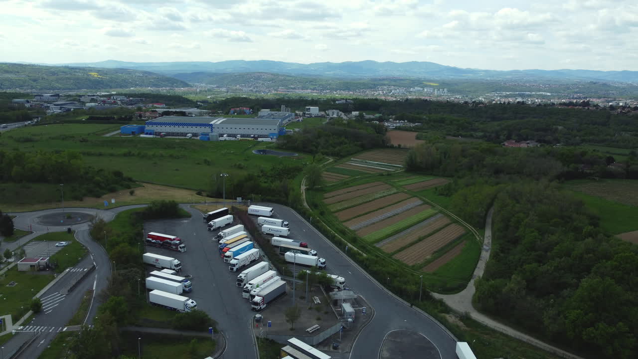 Truck Stop Aerial View with Mountain and Farmland Background