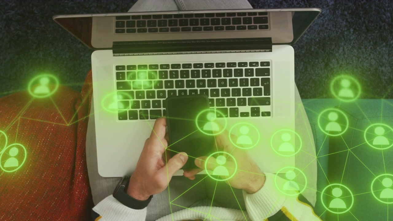 Uomo che tocca e scorre sul telefono, avviando una sovrapposizione verde in movimento, mentre gestisce i feed social sul laptop.