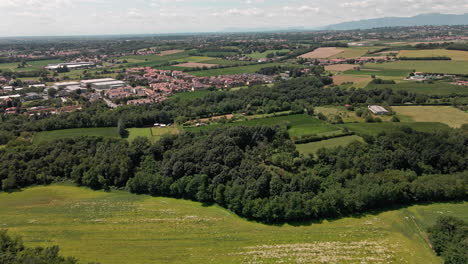 Paisaje-Rural-Con-Casas-Residenciales,-Campos-Verdes-Y-Vegetación-Exuberante-En-Usmate-Velate,-Norte-De-Italia-En-Un-Día-Soleado-De-Verano---Toma-Aérea-De-Drones