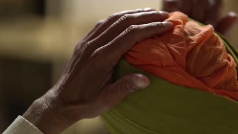 Close-Up-Studio-Shot-Of-Senior-Sikh-Man-With-Beard-Tying-Fabric-For-Turban-Viewed-From-Behind-Shot-In-Real-Time