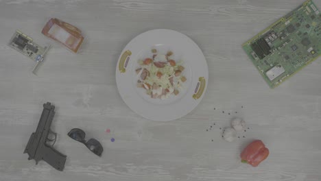 vida muerta con ensalada, piezas de computadora y objetos peligrosos