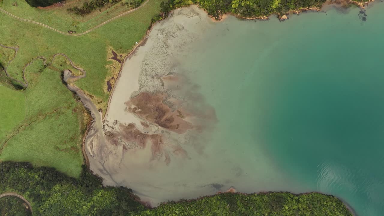 Aerial top down or sandy beach and turquoise water of picton area, New Zealand. Sunny day in summer. River flowing into bay