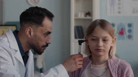 Doctor examining a child's ear with an otoscope