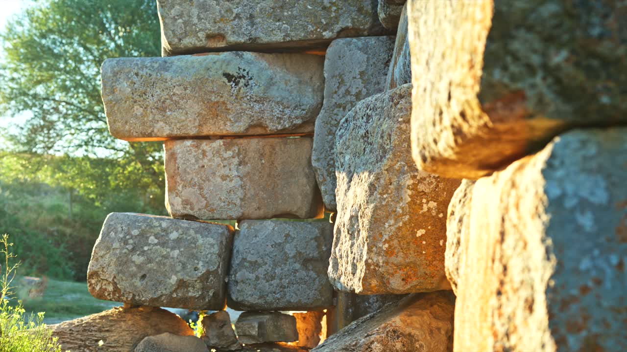 Close-up view of ancient stone blocks basking in the warm sunlight, showcasing the texture and weathering of the historical structure. 8k