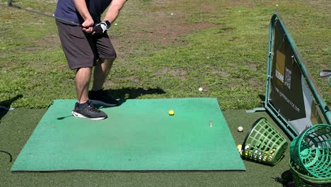 man practicing golf swings on a driving range