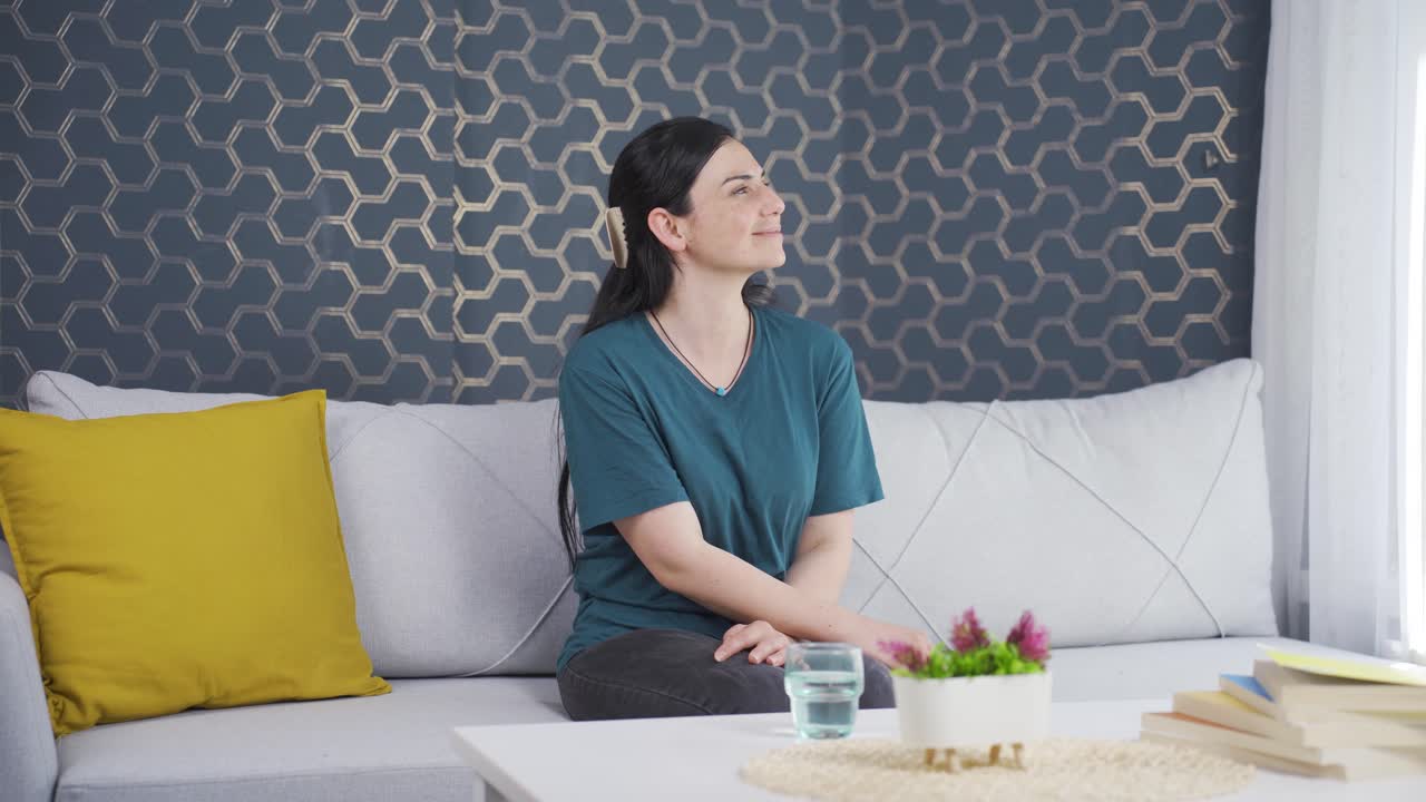 행복하고 평화로운 여성. 그녀는 창문 앞에 앉아 있습니다.