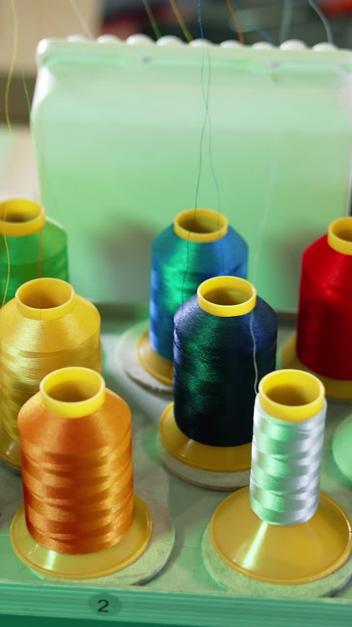 Collection of colorful spools for a dressmaker. Sewing tools for handicraft job. Spools of thread of different colors for tailor. Vertical video