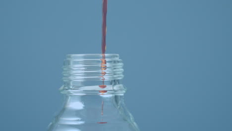 animación de formas rojas sobre líquido que se vierte en la botella