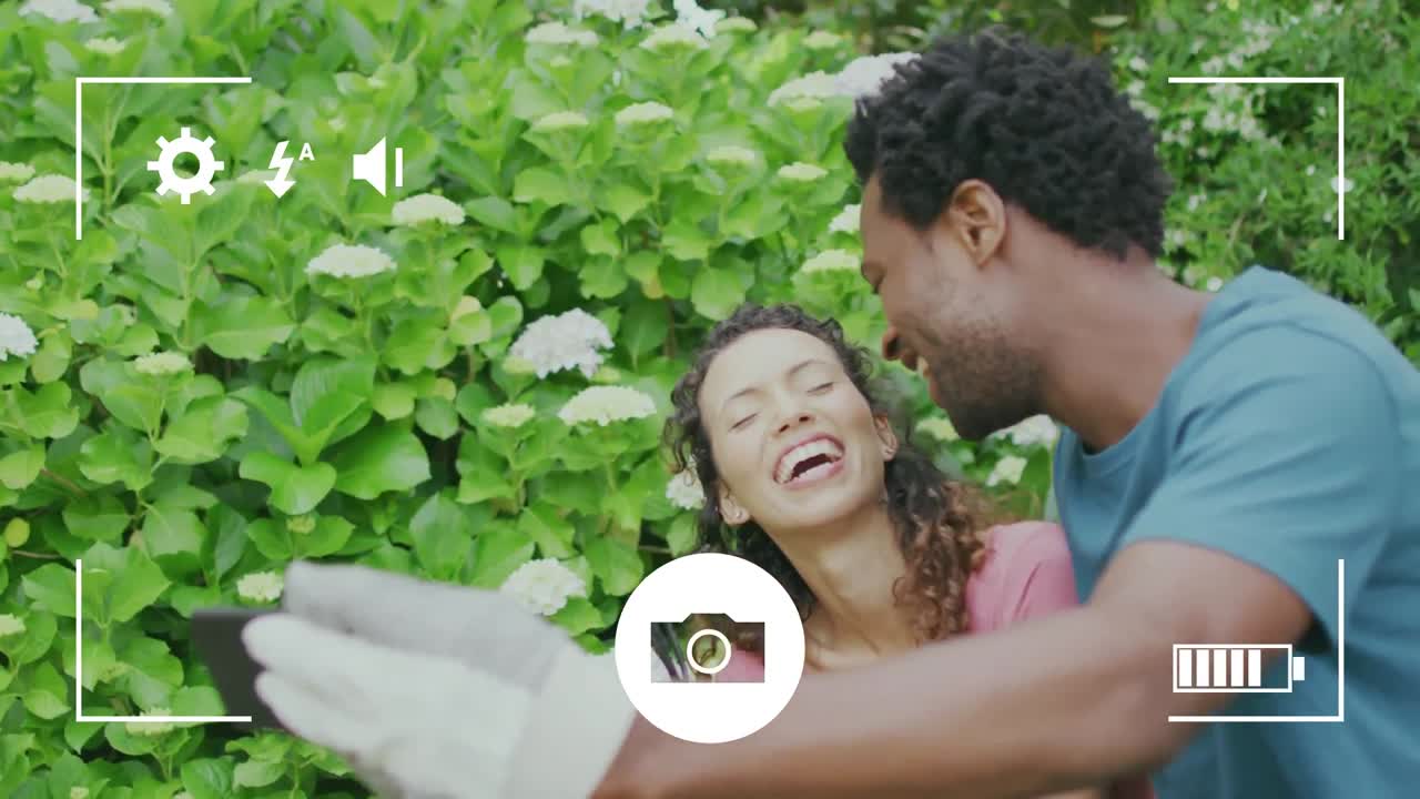 animación de la interfaz de la cámara sobre una feliz pareja biracial que hace jardinería