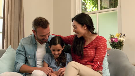 Padres-Felices-Hablando-Con-Su-Hija-En-El-Sofá