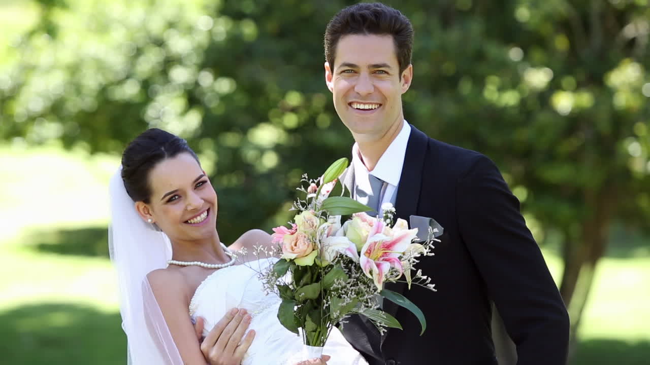 행복 한 신혼 부부 들 이 공원 에서 서 있다