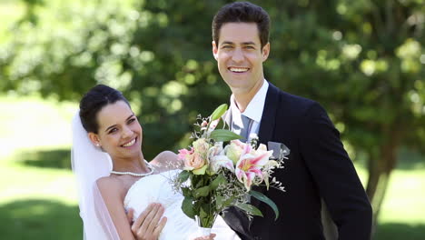 Happy-newlyweds-standing-in-the-park