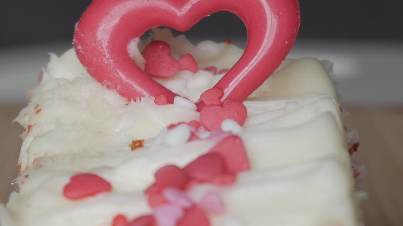 Heart-shaped topper on red velvet brownie with white frosting, love and sweetness theme