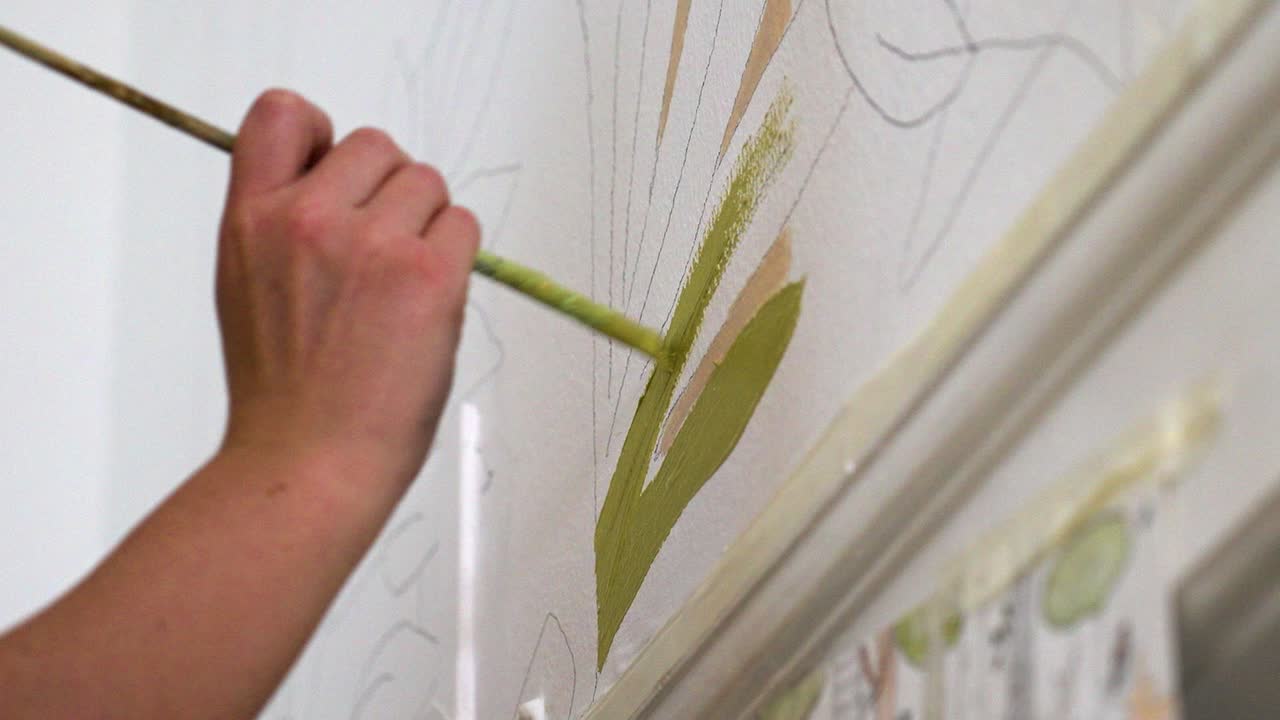 Dipingere a mano motivi colorati su una parete