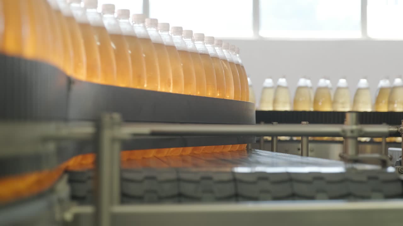 현대 음료 공장에서 주스 또는 물을위한 병을 가진 컨베이어 벨트 - 달한 소다 물의 현대 생산