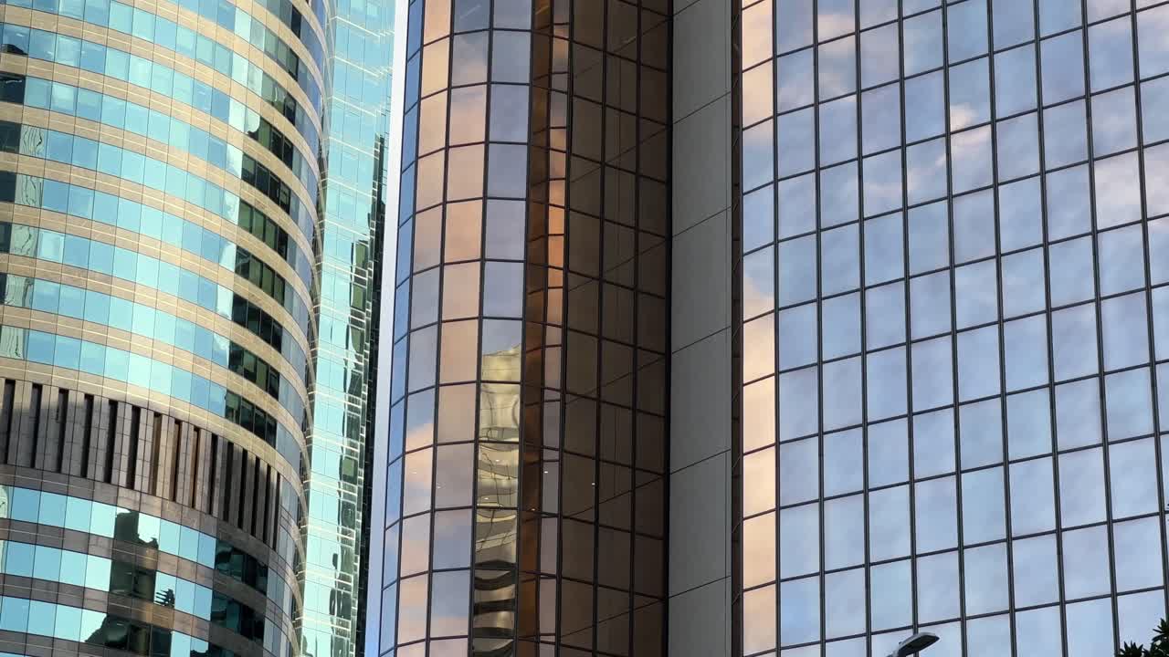 exteriores de edificios corporativos con ventanas de vidrio reflectante que reflejan el hermoso cielo y las nubes en el área metropolitana del centro de la ciudad de brisbane, queensland, qld, tiro panorámico de cerca