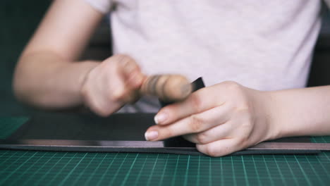 skilled tailor polishes leather with brown slicker closeup