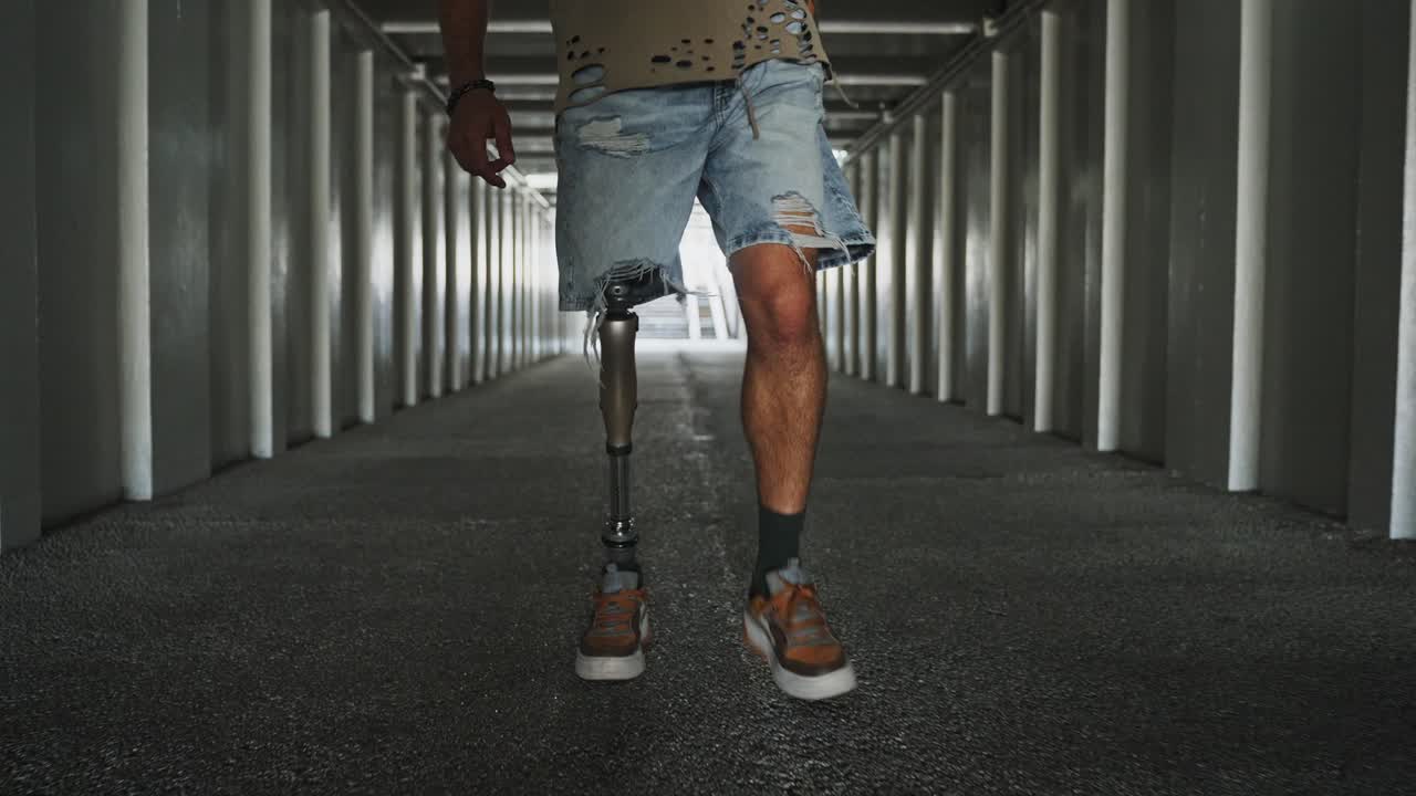 Man with prosthetic leg walking in an urban tunnel