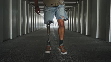man with prosthetic leg walking in an urban tunnel