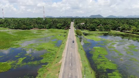 local road surrounded by water in countryside of sri lanka