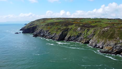 Aerial-view-of-a-coast-with-a-lighthouse-revealed-in-the-background