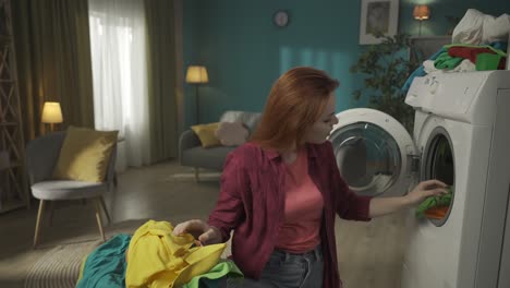woman doing laundry and playing with a teddy bear