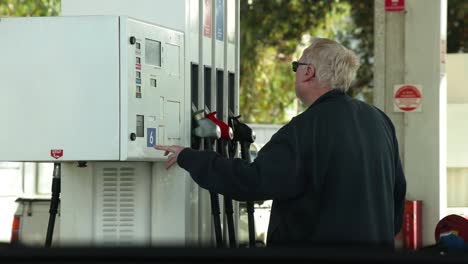 hombre que opera la bomba de combustible en una gasolinera