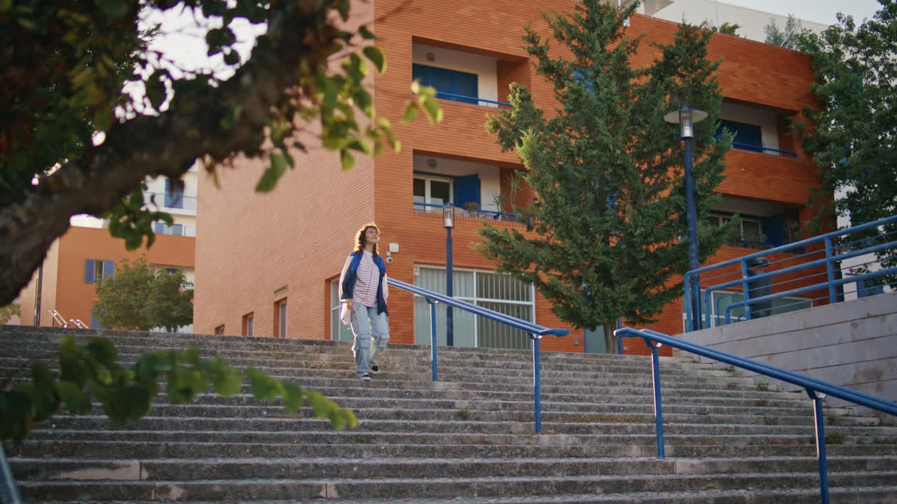 chica casual caminando por las escaleras explorando el distrito urbano. mujer bajando las escaleras