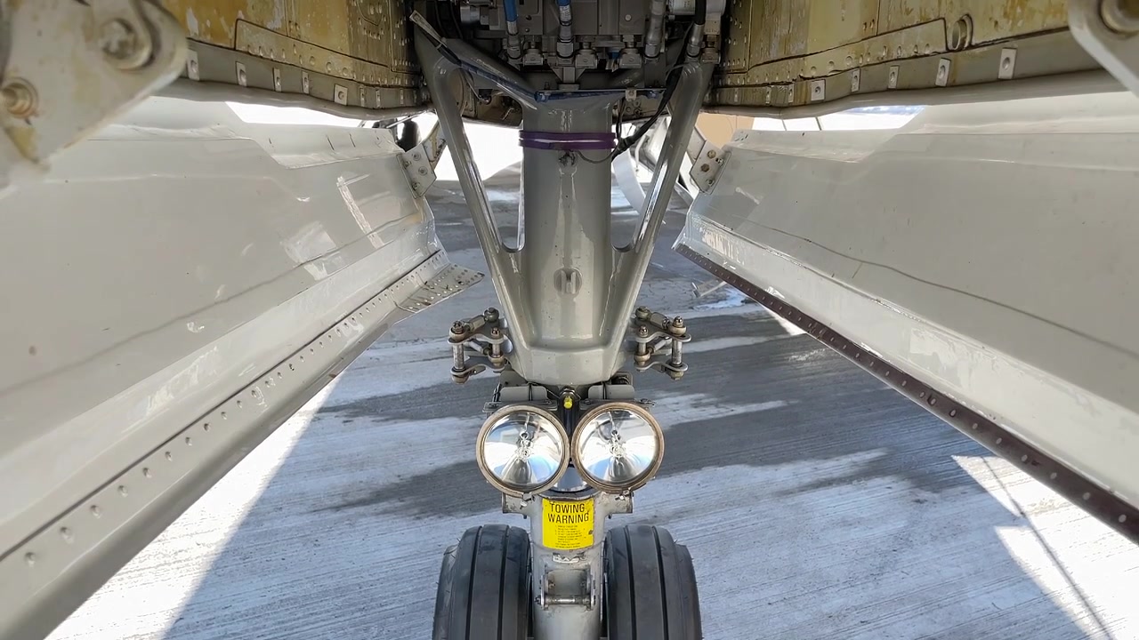 Primo piano del vano del carrello anteriore di un aereo con il carrello di atterraggio. - Ripresa con inclinazione verso il basso