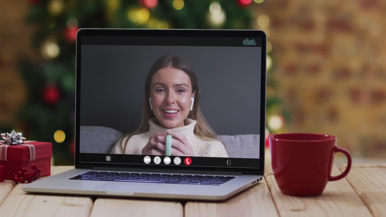 mujer caucásica feliz en videollamada en computadora portátil, con decoraciones de navidad y árbol