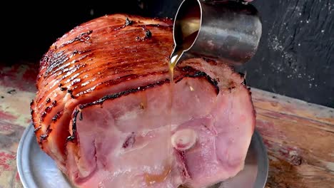 pouring syrup glaze over baked spiral cut ham